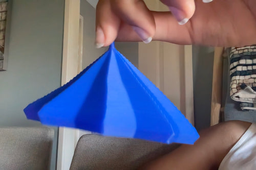 Blue mini star fidget held by its top point